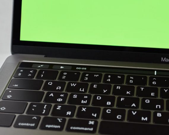 Russian keyboard MacBook Pro with a green screen. Modern electronic device.